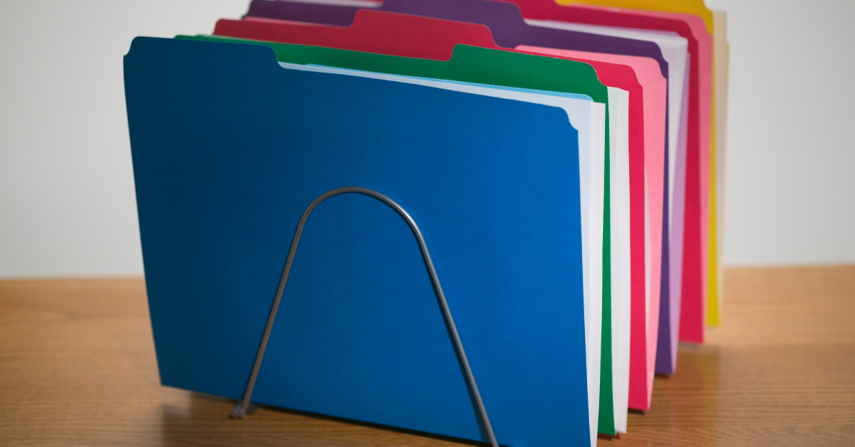 The image centres on a set of brightly coloured flexible plastic folders, each holding sheets of paper.