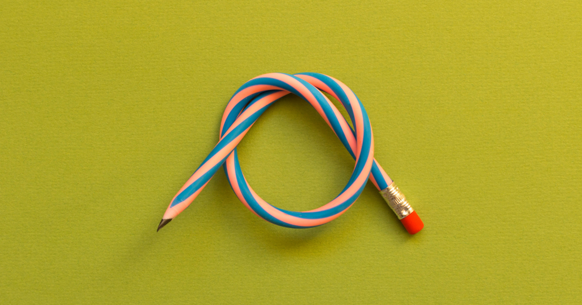 Against a yellow background, a bendy pencil is tied in a knot.