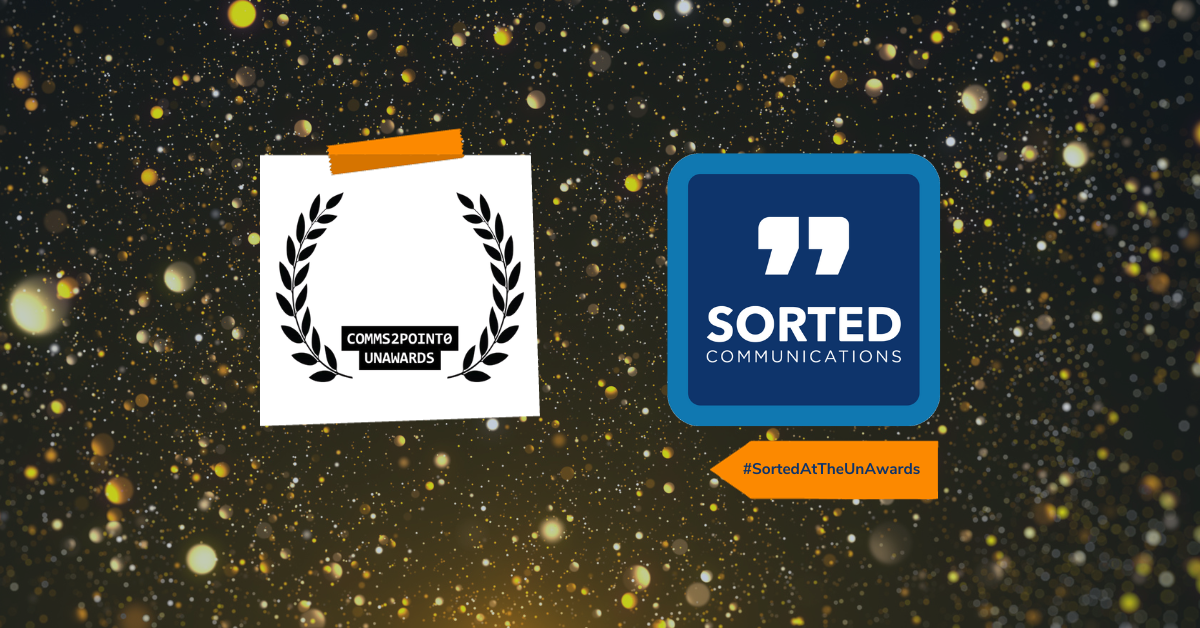 Against a dark background of gold sparkles, on the left is the comms2point0 UnAwards logo and on the right is the Sorted Communications logo. Underneath the Sorted logo is a tag reading #SortedAtTheUnAwards