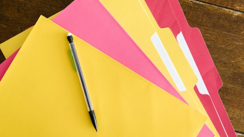 Alternating red and yellow folders piled on top of each other and fanned out.